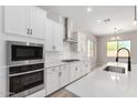 Modern kitchen featuring stainless steel appliances, white cabinets, and a sleek backsplash design at 23769 N 163Rd Dr, Surprise, AZ 85387