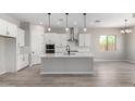 Bright, open kitchen with white cabinets, stainless steel appliances, and a large center island at 23769 N 163Rd Dr, Surprise, AZ 85387