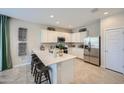 Modern kitchen with white cabinets, stainless steel appliances, and a spacious center island with barstool seating at 24886 N 167Th Dr, Surprise, AZ 85387