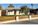 Charming single-story home featuring a well-manicured lawn and a modern horizontal fence at 2827 N 69Th Pl, Scottsdale, AZ 85257