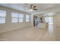 Bright living space with neutral tile flooring, ceiling fan, and abundant natural light from large windows at 36217 N Urika Dr, San Tan Valley, AZ 85140