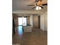 Bright and airy living room featuring tile floors, neutral walls, a ceiling fan, and access to the outdoors at 36217 N Urika Dr, San Tan Valley, AZ 85140