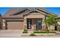 This home features a well-manicured lawn, stone accents, and a covered porch, creating a welcoming curb appeal at 4156 E Bernice St, Gilbert, AZ 85295