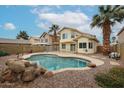 Beautiful backyard featuring a sparkling pool, palm trees, and desert landscaping at 4613 E Douglas Ave, Gilbert, AZ 85234