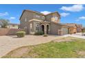 Charming two-story home featuring a well-manicured lawn, desert landscaping, and a welcoming facade at 6409 S 49Th Dr, Laveen, AZ 85339