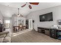 Open-concept living room with dining area, vaulted ceiling, ceiling fan, carpet, and slider to backyard at 8576 W Mclellan Rd, Glendale, AZ 85305