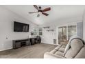 Cozy living room with vaulted ceiling, carpet, ceiling fan, slider to backyard, and neutral paint at 8576 W Mclellan Rd, Glendale, AZ 85305