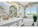 Luxurious bathroom with double sinks, elegant fixtures, soaking tub, and marble finishes at 8781 S Mill Ave, Tempe, AZ 85284