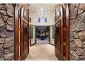 Grand entrance featuring ornate wooden doors, stone walls, and a view of a beautifully lit courtyard at 10040 E Happy Valley Rd # 269, Scottsdale, AZ 85255