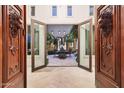 Grand entrance featuring ornate wooden doors, stone walls, and a view of a beautifully lit courtyard at 10040 E Happy Valley Rd # 269, Scottsdale, AZ 85255
