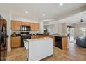 Open kitchen boasts wood cabinets, a movable island, and black appliances, offering plenty of counter space at 10134 E Meandering Trail Ln, Gold Canyon, AZ 85118