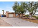 Single story home featuring xeriscape landscaping, long driveway, and two car garage at 1031 W Cornell Dr, Tempe, AZ 85283