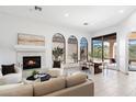 Bright living room featuring a fireplace, tile floors, multiple windows, and comfortable seating for relaxing and entertaining at 10613 E Blanche Dr, Scottsdale, AZ 85255