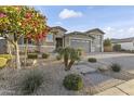 Beautiful home with professional landscaping featuring trees, shrubs, and decorative rocks at 12531 W Tuckey Ln, Glendale, AZ 85307