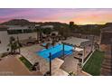 Resort-style pool featuring a covered lounge area, mature landscaping, and desert views at 1523 N 103Rd St, Mesa, AZ 85207