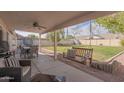 Spacious covered patio, perfect for entertaining, with a porch swing overlooking the grassy backyard at 1550 E Park Ave, Gilbert, AZ 85234