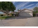 Well-maintained single-story home with a spacious driveway and attached two-car garage, complemented by lush landscaping at 1550 E Park Ave, Gilbert, AZ 85234
