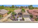 Aerial view of a home on a golf course with desert landscaping, private drive, and a tile roof at 17443 N Goldwater Dr, Surprise, AZ 85374