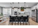 Modern kitchen island with black cabinets, quartz countertop, bar stools and stainless steel appliances at 19443 W Valle Vista Way, Litchfield Park, AZ 85340