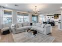 Bright living room with plush sectional, large windows, and wood floors, offering ample seating at 19443 W Valle Vista Way, Litchfield Park, AZ 85340