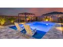 Inviting backyard featuring a luxurious pool with tanning ledge, pergola and lounge chairs at 19443 W Valle Vista Way, Litchfield Park, AZ 85340