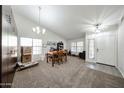 Bright living room featuring neutral carpet, vaulted ceiling, and abundant natural light at 19622 N 66Th Ln, Glendale, AZ 85308