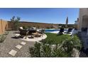 Desert backyard with a hammock, swimming pool, patio furniture, and drought resistant plants at 26904 W Kerry Ln, Buckeye, AZ 85396