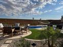 Desert backyard with a hammock, swimming pool, patio furniture, and drought resistant plants at 26904 W Kerry Ln, Buckeye, AZ 85396