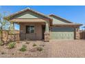 Charming home featuring stone accents, a two-car garage, and a well-maintained front yard at 33395 N 132Nd Dr, Peoria, AZ 85383