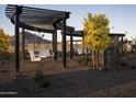 Charming swing set with white swings under a modern pergola, surrounded by manicured landscaping at 3501 W Sunstone Dr, San Tan Valley, AZ 85144