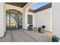 Inviting front porch with stylish seating, decorative door, and patterned brick flooring for a welcoming entrance at 3939 W Fox Rd, Laveen, AZ 85339