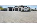 Spacious 3-car garage with dark doors and a large paved driveway, offering ample parking space at 3939 W Fox Rd, Laveen, AZ 85339