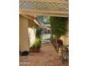 Charming outdoor patio area with brick pavers, lush greenery, and comfortable seating under a pergola at 50 W Calle De Arcos --, Tempe, AZ 85284
