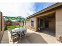A cozy covered patio with an outdoor dining set and fan, great for entertaining or relaxing at 6796 W Evergreen Ter, Peoria, AZ 85383