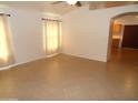 An empty living room features tile flooring, neutral walls, and natural light through a window at 10302 E Cicero Cir, Mesa, AZ 85207