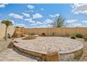 Paver patio with a built-in fire pit, rock details, and desert landscaping, perfect for outdoor entertaining at 10841 W Nosean Rd, Peoria, AZ 85383