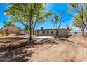 Lush backyard view showing the neutral home, outbuilding, and a large concrete patio, ideal for outdoor entertainment at 11124 W Southern Ave, Tolleson, AZ 85353