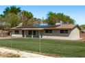 Single story home featuring solar panels, chain link fence, well kept lawn, and a tranquil suburban setting at 11124 W Southern Ave, Tolleson, AZ 85353