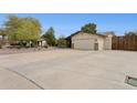 Expansive driveway leading to a two-car garage, complemented by desert landscaping and mature trees at 12809 N 50Th St, Scottsdale, AZ 85254