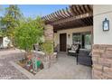 Charming front porch with a pergola, stone accents, and comfortable seating for relaxing outdoors at 12809 N 50Th St, Scottsdale, AZ 85254