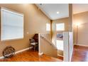 Hallway with hardwood floors, neutral walls, a staircase and multiple windows creating a bright, inviting space at 14575 W Mountain View Blvd # 925, Surprise, AZ 85374