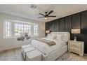 Large bedroom features a window seat, wood accent wall, and stylish ceiling fan at 18624 N 4Th Ave, Phoenix, AZ 85027