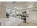 Bright kitchen features quartz countertops, stainless steel appliances, skylight, and a view to the backyard at 18624 N 4Th Ave, Phoenix, AZ 85027