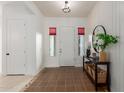 Bright and inviting home entry with decorative tile flooring, a hall table, and a stylish mirror at 19675 E Oriole Way, Queen Creek, AZ 85142