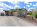 Beautiful home featuring a long driveway, tan garage door and desert landscaping at 265 W Rainbow Bridge Ln, San Tan Valley, AZ 85140