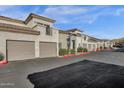 Street view of an apartment complex with individual garages and desert landscaping at 3236 E Chandler Blvd # 2057, Phoenix, AZ 85048