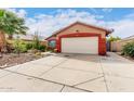 View of the two-car garage and front lawn, with beautiful desert landscaping details at 3363 W Lone Cactus Dr, Phoenix, AZ 85027