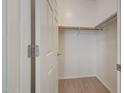 A simple, walk-in closet with a wooden hanging bar and tile floors at 6221 S 45Th Gln, Laveen, AZ 85339