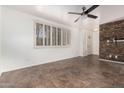 Spacious living room with tile flooring, shutters, a ceiling fan, and an accent wall of stacked stone at 6837 E Osborn Rd # F, Scottsdale, AZ 85251