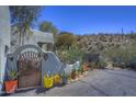 Southwestern home exterior with desert landscaping, cactus, and a decorative gate at 8619 E Silver Saddle Dr, Carefree, AZ 85377